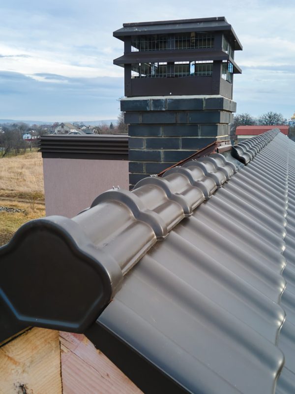 Closeup of house roof top covered with ceramic shingles. Tiled covering of building under construction.